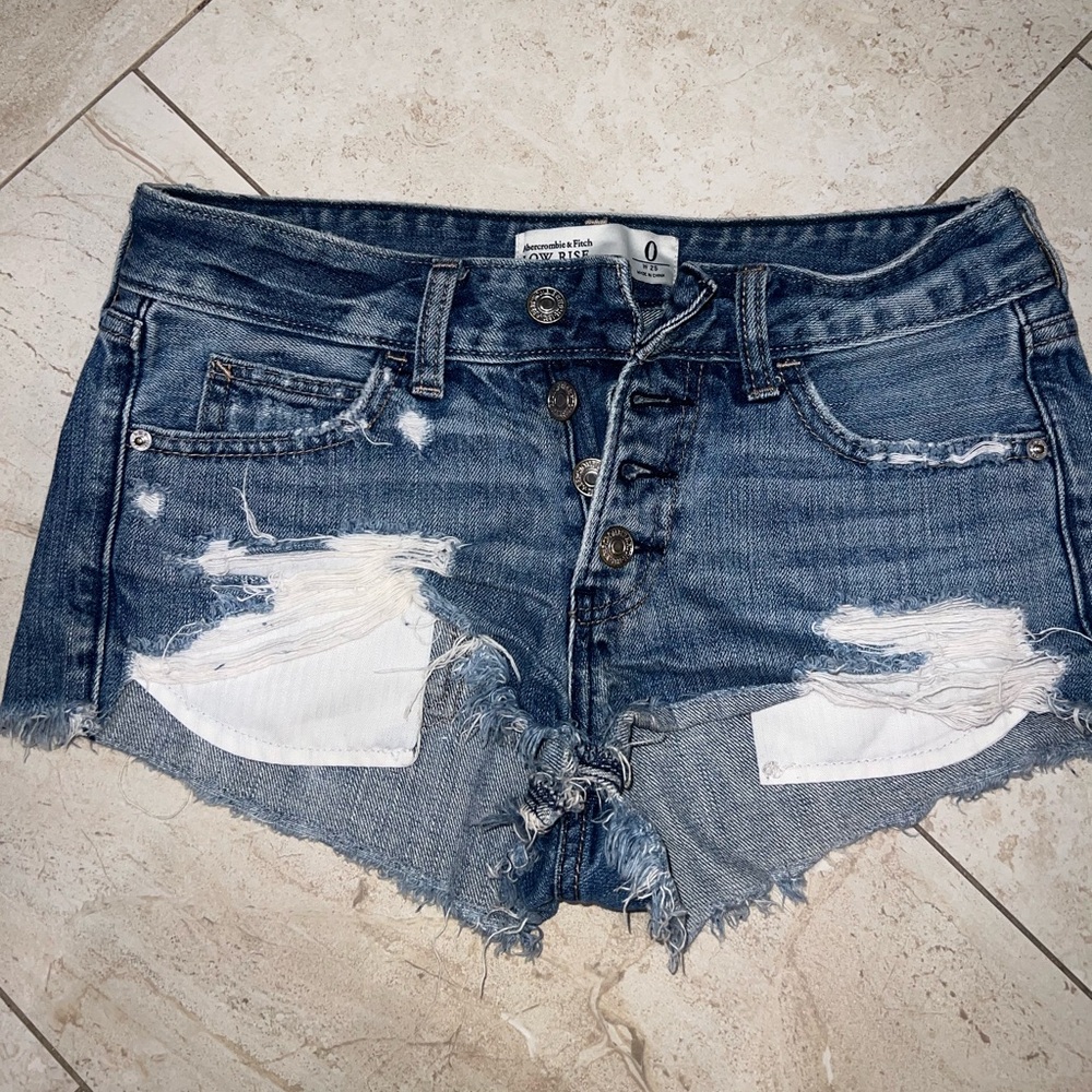Abercrombie low rise denim distressed shorts 
Size 0/25”